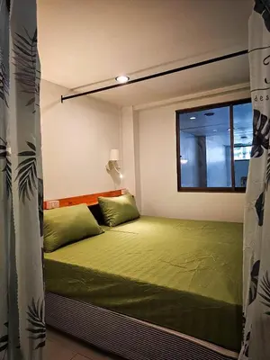 a small bed in a room with a window at MT Friend Hostel Phuket Town in Phuket Town