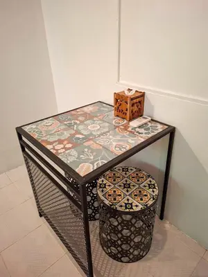 a table with a stool and a box on top at MT Friend Hostel Phuket Town in Phuket Town