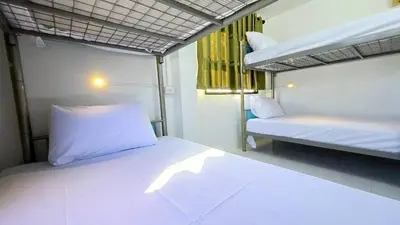 a small room with two bunk beds and a window at MT Friend Hostel Phuket Town in Phuket Town