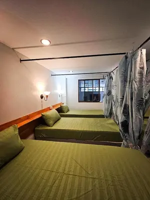 a room with two beds and a window at MT Friend Hostel Phuket Town in Phuket Town