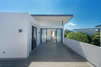 a balcony of a house with white walls and glass doors at Luxury 5 bedroom villa Laguna Park in Laguna Phuket