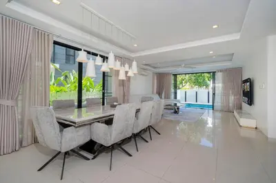 a dining room with a glass table and chairs at Luxury 5 bedroom villa Laguna Park in Laguna Phuket