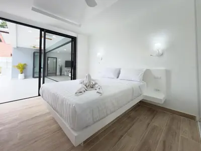 a white bedroom with a large bed with white sheets at Stylish 3BR Pool Villa Lawan Villa (LWV1) in Phuket Town