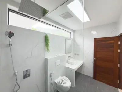 a bathroom with a toilet and a sink and a window at Stylish 3BR Pool Villa Lawan Villa (LWV1) in Phuket Town