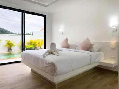 a white bedroom with a large bed with a large window at Stylish 3BR Pool Villa Lawan Villa (LWV1) in Phuket Town