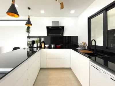 a kitchen with white cabinets and black countertops at Stylish 3BR Pool Villa Lawan Villa (LWV1) in Phuket Town