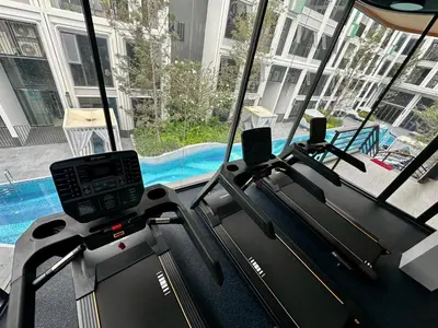 a gym with two treadmill machines and a pool at Bangtao Studio Bellevue Lagoon 6floor pool view in Laguna Phuket