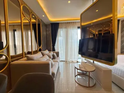 a living room with a couch and a tv at Bangtao Studio Bellevue Lagoon 6floor pool view in Laguna Phuket