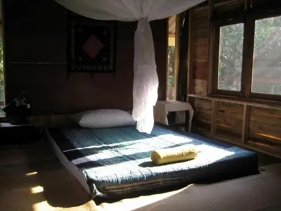 a bed with a canopy in a room with windows at Lanlay Home Stay Krabi in Ao Luk