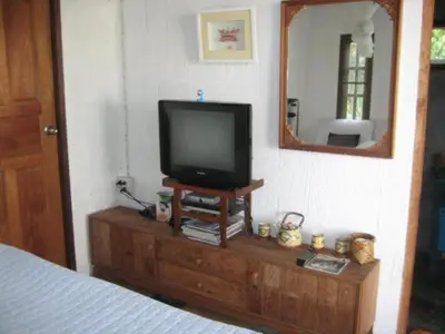 a television sitting on top of a dresser with a mirror at Lanlay Home Stay Krabi in Ao Luk