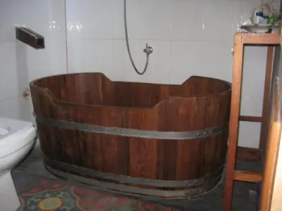 a wooden bath tub in a bathroom with a toilet at Lanlay Home Stay Krabi in Ao Luk