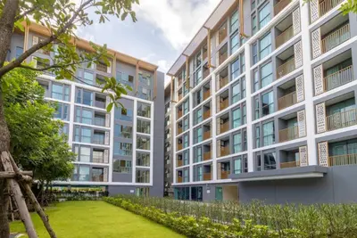 an apartment building with a lawn in front of it at The Ozone Condominium B130 Laguna in Laguna Phuket