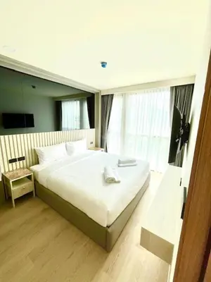 a bedroom with a large white bed in front of a window at The Ozone Condominium B130 Laguna in Laguna Phuket