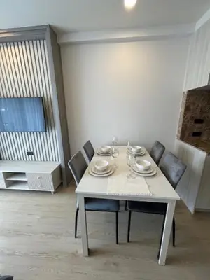 a table with chairs and plates on it in a room at The Ozone Condominium B130 Laguna in Laguna Phuket