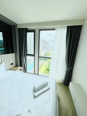 a bedroom with a white bed and a large window at The Ozone Condominium B130 Laguna in Laguna Phuket