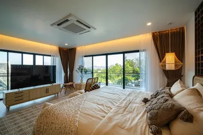 a large bedroom with a large bed and a large window at Phu Talae Villa Rawai Beach in Ban Klang