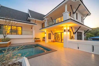 a house with a swimming pool in front of it at Phu Talae Villa Rawai Beach in Ban Klang