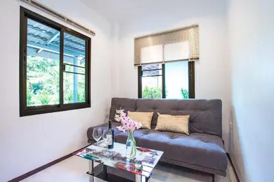 a living room with a couch and a table at Oxavia Garden Bungalow B1 -B2 Nai Harn in Rawai Beach
