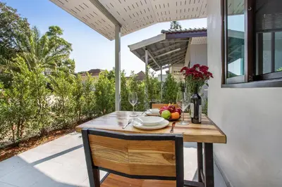 a table with a bowl of fruit and wine glasses at Oxavia Garden Bungalow B1 -B2 Nai Harn in Rawai Beach