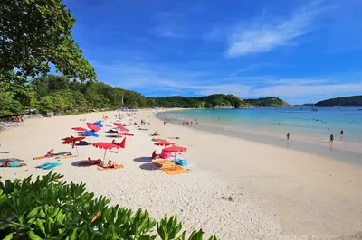 a beach with a lot of people and umbrellas at Oxavia Garden Bungalow B1 -B2 Nai Harn in Rawai Beach