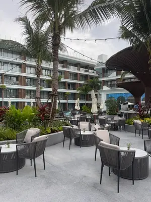 a patio with chairs and tables in front of a building at Sunshine Beach, Kora Resort Phuket 5, Bang Tao, Laguna in Bang Tao Beach