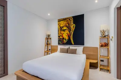 a bedroom with a white bed and a painting on the wall at 2BR Modern Pool Villa Near the Sea V261 in Thalang