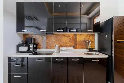 a kitchen with black cabinets and a sink at 2BR Modern Pool Villa Near the Sea V261 in Thalang