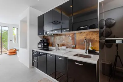 a kitchen with black cabinets and a sink at 2BR Modern Pool Villa Near the Sea V261 in Thalang