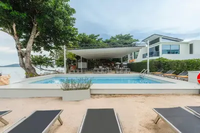 a swimming pool in front of a house at C244 Ocean Breeze 1BR Studio Steps from the Sea in Ban Saiyuan (1)