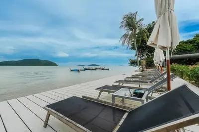 a row of tables and umbrellas on a dock at C244 Ocean Breeze 1BR Studio Steps from the Sea in Ban Saiyuan (1)