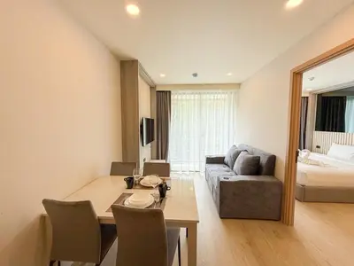 a living room with a table and a couch at C246 New 1BR Condo with Pool, Gym &Great Location in Thalang