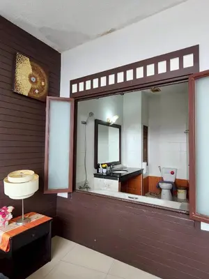a bathroom with a toilet and a sink and a mirror at The Rest Phuket in Phuket Town