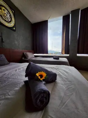 a room with three beds with a flower on them at The Rest Phuket in Phuket Town