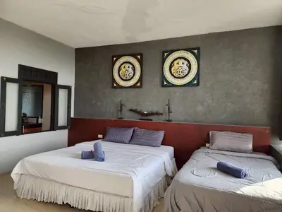 a bedroom with two beds and two mirrors on the wall at The Rest Phuket in Phuket Town