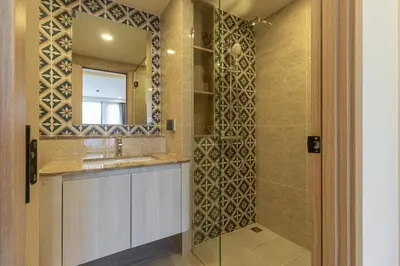 a bathroom with a shower with a sink and a mirror at C247 Brand-New Condo with Pool, Gym & Beach Nearby in Thalang
