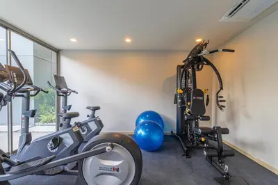 a gym with two treadmills and two exercise bikes at C247 Brand-New Condo with Pool, Gym & Beach Nearby in Thalang