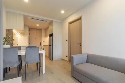 a living room with a couch and a table and chairs at C247 Brand-New Condo with Pool, Gym & Beach Nearby in Thalang