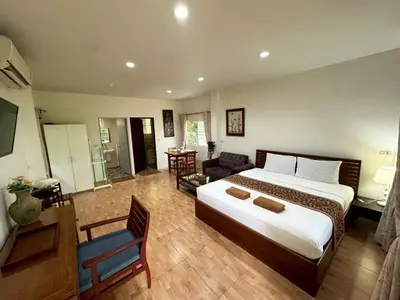 a bedroom with a large bed and a living room at Floresh Freedom Hostel in Phuket