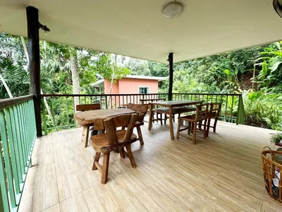 a deck with wooden tables and chairs on it at Floresh Freedom Hostel in Phuket