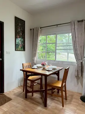 a dining room table with chairs and a window at Floresh Freedom Hostel in Phuket