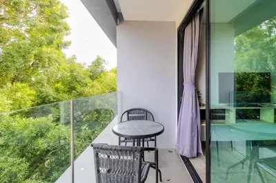 a balcony with a table and chairs and a window at C248 Condo 3 Min to Nai Harn Beach 1BR with Rooftop Pool in Rawai Beach
