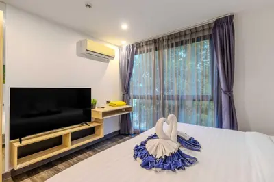 a bedroom with a large bed with a swan on it at C248 Condo 3 Min to Nai Harn Beach 1BR with Rooftop Pool in Rawai Beach