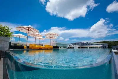 a large swimming pool with umbrellas on top of it at C248 Condo 3 Min to Nai Harn Beach 1BR with Rooftop Pool in Rawai Beach