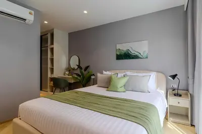 a bedroom with a large white bed with green sheets at C249 Brand new Pool view stay with great amenity in Bang Tao Beach