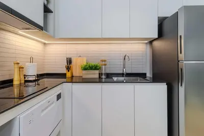 a kitchen with white cabinets and a stainless steel refrigerator at C249 Brand new Pool view stay with great amenity in Bang Tao Beach
