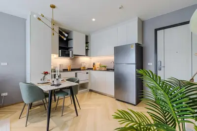 a kitchen with a table and chairs and a refrigerator at C250 Brand new Stay near top beach & Boat Avenue in Thalang