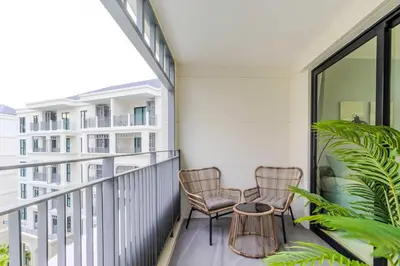 a balcony with two chairs and a table at C250 Brand new Stay near top beach & Boat Avenue in Thalang