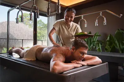 a man in a bathtub with a man laying in it at Keemala - Clay Pool Cottage in Kamala Beach
