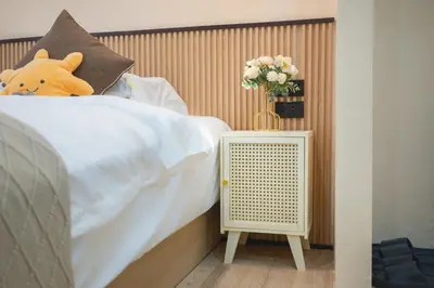 a teddy bear sitting on a bed next to a radiator at Amaleena Pool Access Suites in Ban Bang Chak