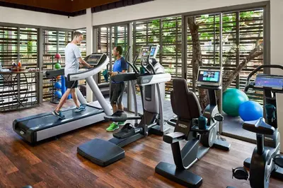 two people exercising on cardio machines in a gym at Keemala - Birds Nest Pool Villa in Kamala Beach